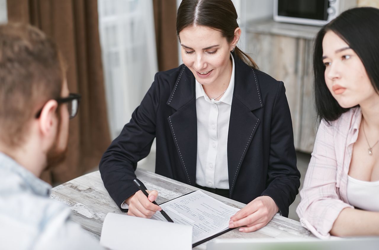 A business meeting with a diverse team indoors, discussing documents and investments.